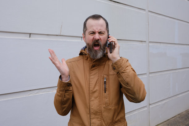 一个拿着智能手机站着的男人。图片下载