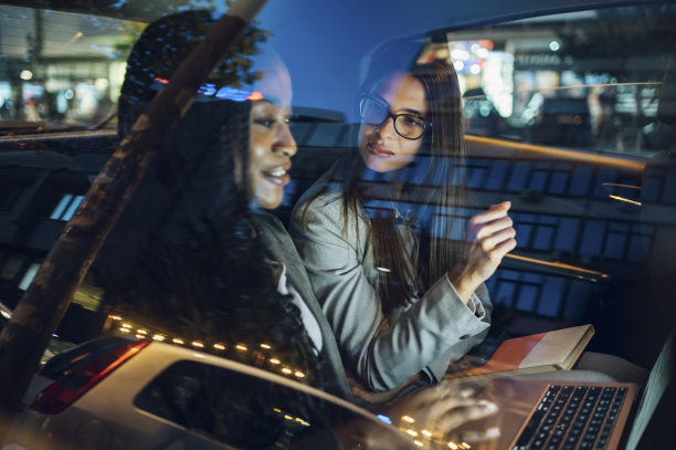 两个多种族女商人开着一辆车，用着一台笔记本电脑图片下载