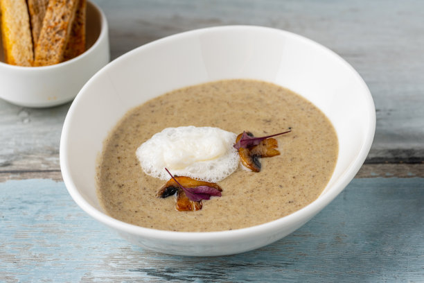 木桌上白瓷碗盛奶油蘑菇汤图片下载