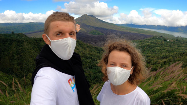 图为，一对戴着口罩的年轻白种夫妇在以山海为背景的地方与朋友和家人进行视频通话。covid-19大流行期间的浪漫度假。图片下载