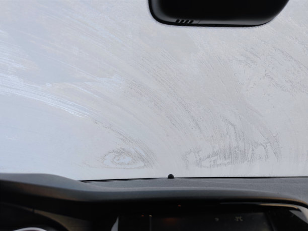 在寒冷的冬天，一辆汽车停在外面的街道上，一个没有品牌的冰冻挡风玻璃的内部图片下载