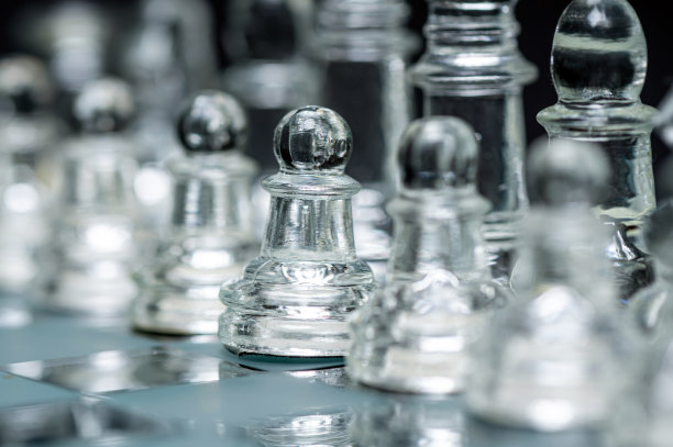 玻璃，透明棋盘上的棋子，选择性聚焦，特写，孤立在黑色上图片下载