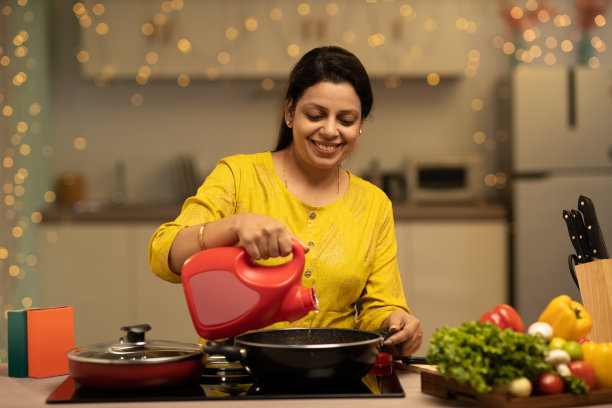 印度妇女在厨房做饭时享受的肖像。库存图片图片下载