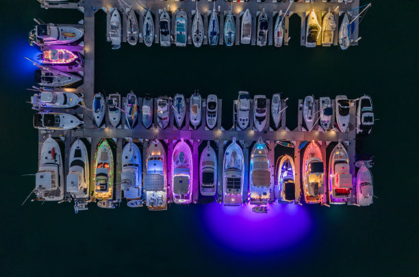 黄昏时停靠在码头的灯火通明的船只图片下载