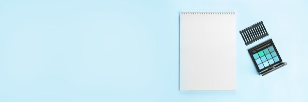 托盘的阴影和涂抹器与白色记事本上的蓝色背景。横幅。图片下载