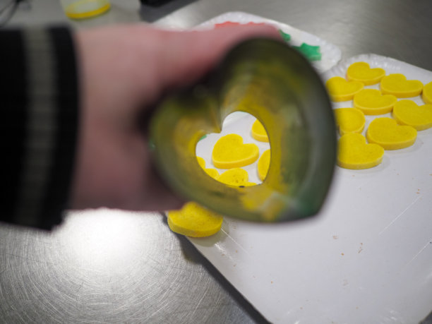 糕点师切红、紫、黄、绿星形和心形的彩色小圆面包图片下载