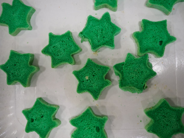 糕点师切红、紫、黄、绿星形和心形的彩色小圆面包图片下载