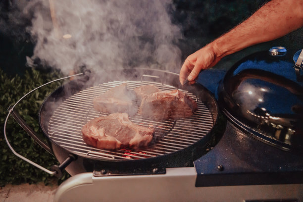 烤肉的特写照片。背景中，朋友和家人正坐着等着吃饭图片下载