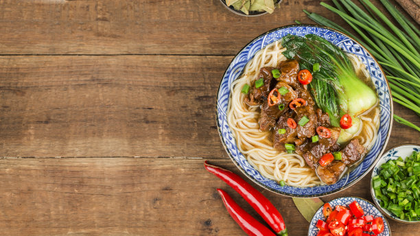 麻辣红汤牛肉面放在木桌上的碗里图片下载