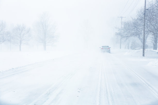 在眩目的暴风雪中几乎看不到前方的汽车图片下载