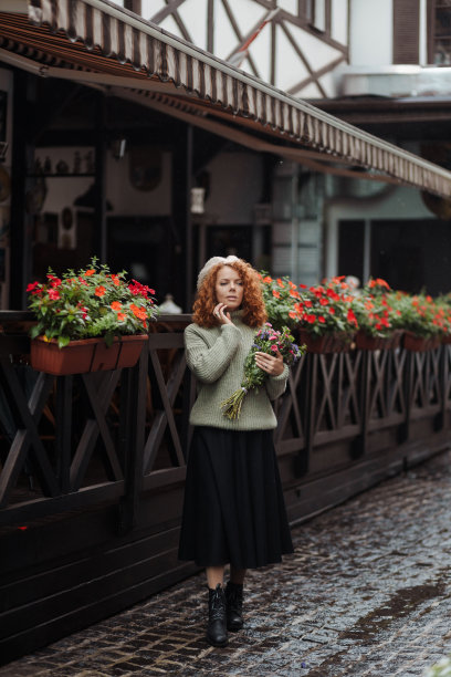 女子肖像在贝雷帽毛衣拿着一束花的餐厅背景图片下载