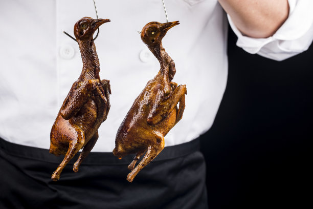 传统的广式烤鸽放在白瓷盘上图片下载