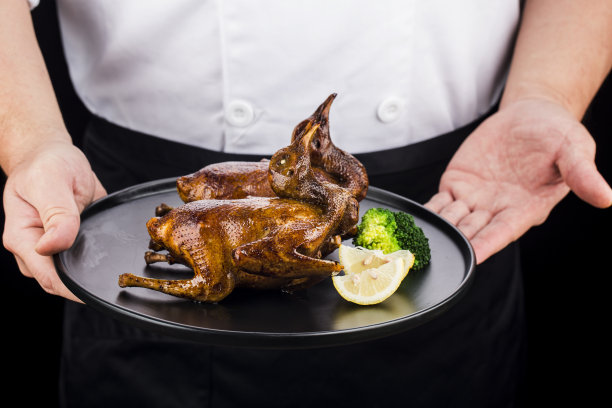 传统的广式烤鸽放在白瓷盘上图片下载