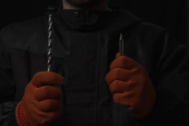 手持无绳电动螺丝刀，螺丝和钻孔钻头隔离在黑色背景上图片下载