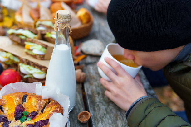 秋天的野餐，木桌上有热茶、糕点和三明治图片下载