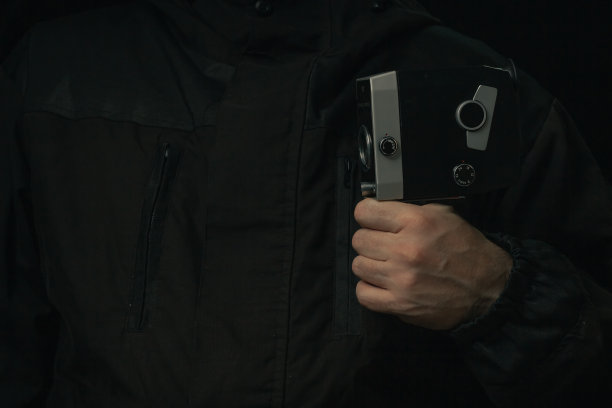 老式电影相机在男子手中孤立的黑色背景图片下载