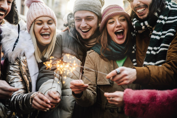 亲密的快乐的朋友享受与烟火的形象-一群年轻人庆祝新年除夕与烟花-假期和友谊的概念图片下载