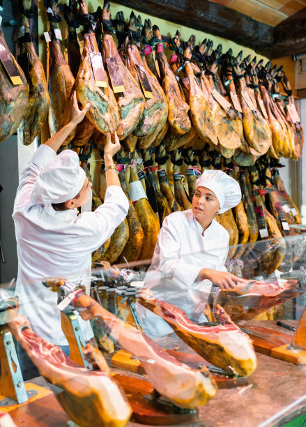 肉店老板和店员卖西班牙火腿图片下载