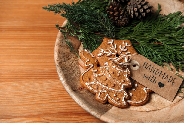 便宜的圣诞礼物，便宜的圣诞预算礼物的想法。圣诞自制姜饼饼干带，冷杉树和手工与爱标签在木桌上图片下载