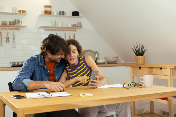 幸福的年轻夫妇在用电话图片下载