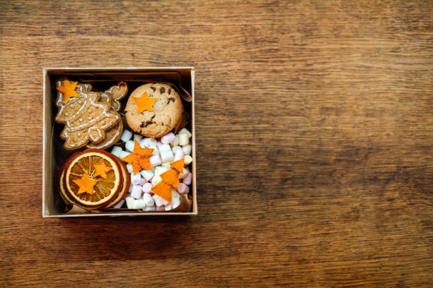 圣诞自制甜蜜篮。圣诞甜蜜礼盒。成人和孩子的节日礼物篮的想法。盒装自制饼干和橘子片图片下载