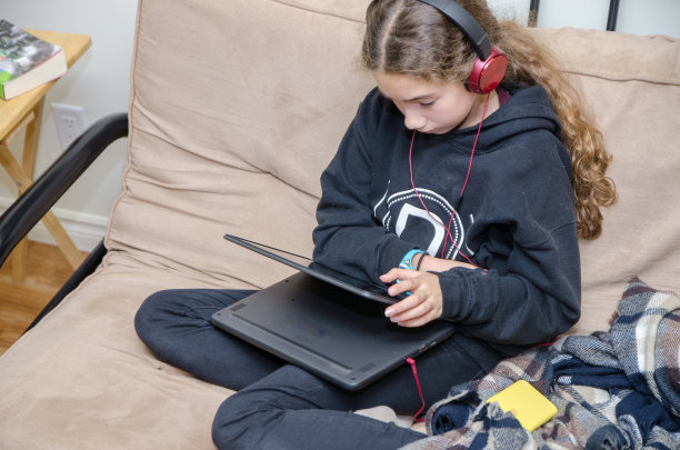 十几岁的女孩在笔记本电脑上看视频图片下载