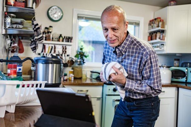 老爷子在厨房用平板看广播图片下载