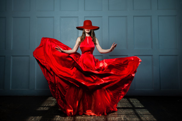 美丽的时尚模特女人在红色丝绸连衣裙和红色宽檐帽。《美丽女人》全像图片下载