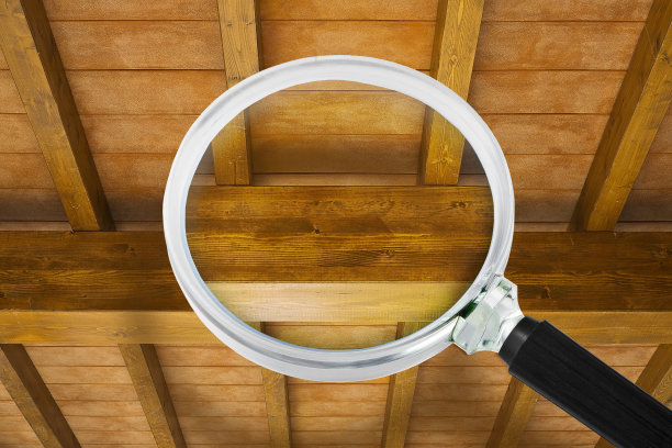 木结构的保养、维护和监督。新的木桁架结构与横梁和木制屋顶-概念看到通过放大镜图片下载