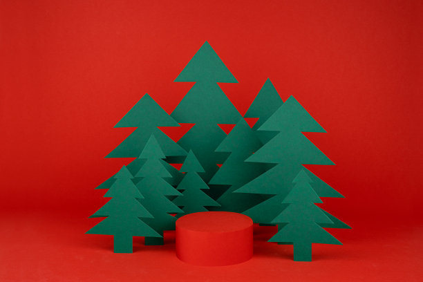 鲜红色的新年背景与红色圆柱裙台模型，绿色的纸云杉作为森林在节日的现代风格为介绍化妆品，礼品，复制空间。圣诞节广告模板。图片下载