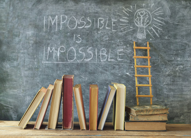 黑板上写着“不可能”的精装书。学习、教育、人格发展、成功阶梯、返校理念。图片下载
