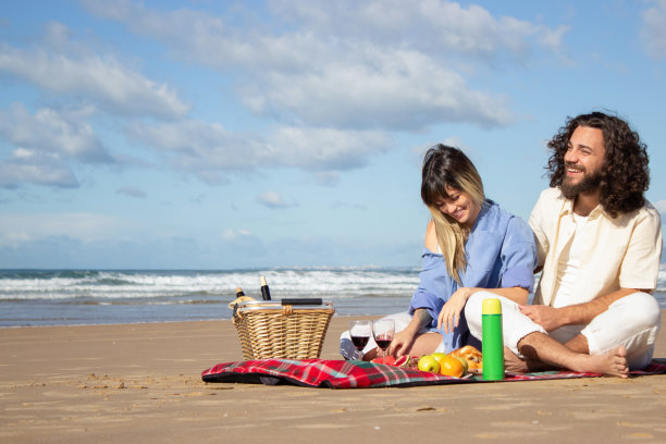 幸福的夫妇在海滩享受野餐图片下载