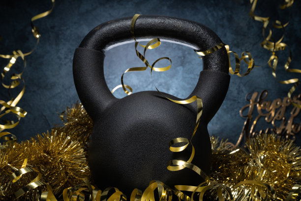 健身跨年作文，用健身房的壶铃和金色装饰。新年概念的锻炼决心。图片下载