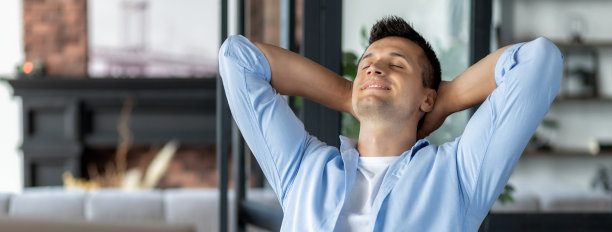 梦想美好的未来，想象新的机会。满意的年轻男性商人在办公室休息的工作场所，把他的手放在脑后图片下载