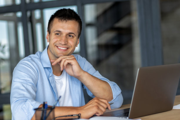 成功快乐的人，办公室职员或企业家，在现代办公室工作，看向别处，思考一些事情，友好地微笑图片下载