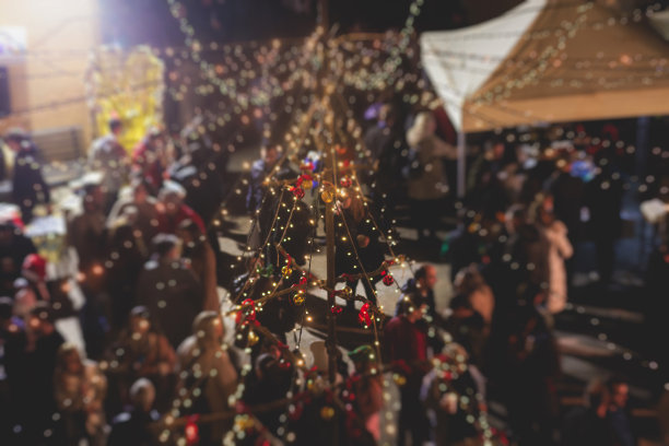 拥挤的圣诞集市上有新年装饰品，气球，花环和鲜花，圣诞集市内部，零售亭和商店的照明，摊位上有手工制作的礼物和纪念品图片下载