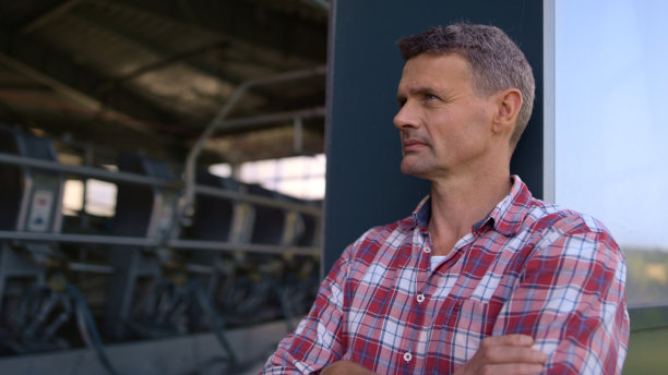 农民休息的奶牛场在生产设施的特写。工人检查挤奶图片下载