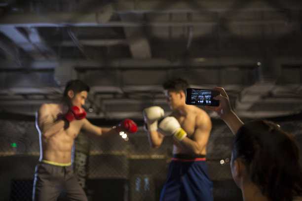 一名女拳迷用智能手机拍摄比赛瞬间图片下载