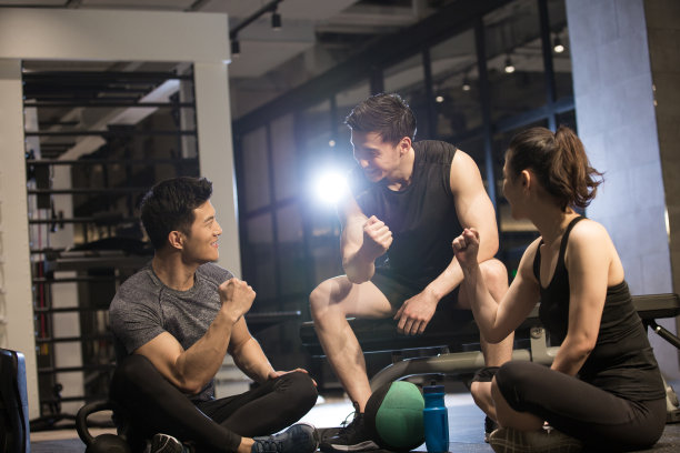 三个年轻人在健身房放松聊天图片下载