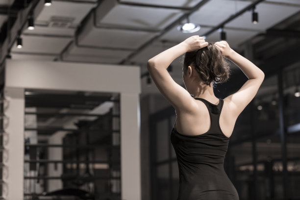 一个年轻的女运动员在体育馆里扎头发图片下载