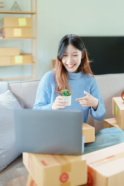 创业创业的独立亚洲妇女微笑着用电脑笔记本电脑与愉快的成功网上营销包装盒项目和中小企业交付的概念图片下载