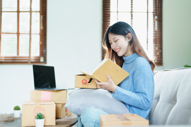 创业创业的独立亚洲妇女微笑着用电脑笔记本电脑与愉快的成功网上营销包装盒项目和中小企业交付的概念图片下载