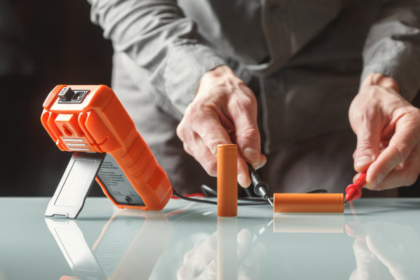 电工用万用表测量电池电压。图片下载