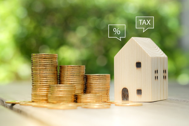 百分比标志和税收的言论泡沫从房子与钱硬币堆栈。房地产概念。房产投资，贷款，抵押，税收。房价或利率上升。图片下载