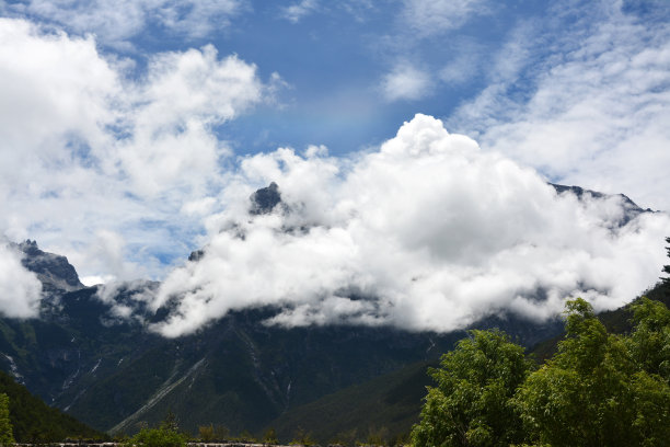 在阳光明媚的日子里，蓝天下，白云在山上图片下载