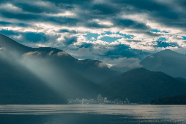 被云包围的山。黄昏的光线照耀着村庄。图片下载