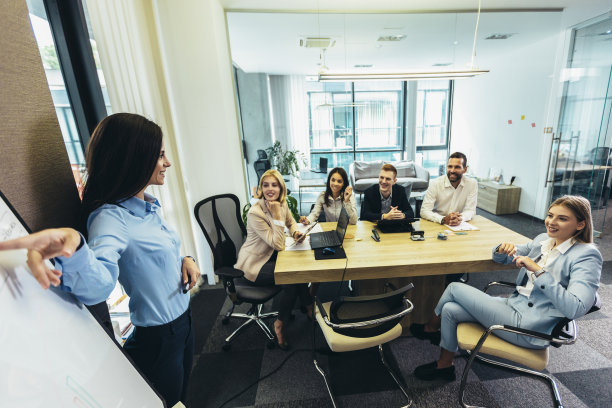 一个女商人在会议室的白板上向她的同事做报告图片下载