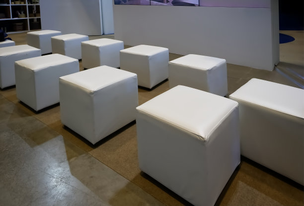 立方体形状的皮革软垫椅子排列在展厅，室内背景图片下载
