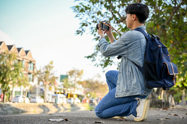 帅气的亚洲男性游客或旅行者用他的复古相机拍摄清迈老城的照片图片下载
