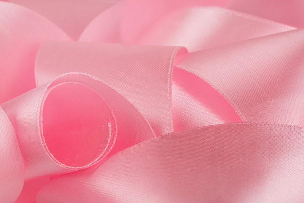 粉红色缎带，缠绕在桌子上，孤立在白色背景上图片下载